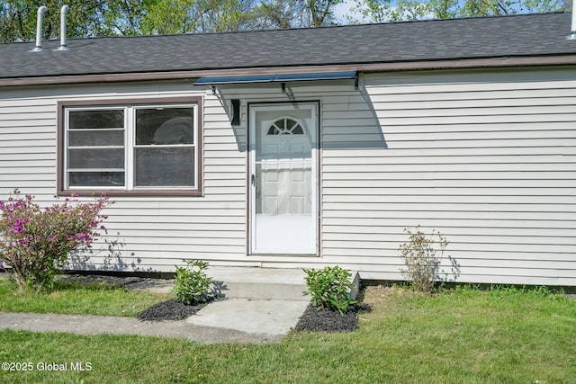 12 Jones Dr, Colonie, NY 12309 - view of exterior entry featuring a shingled roof and a lawn