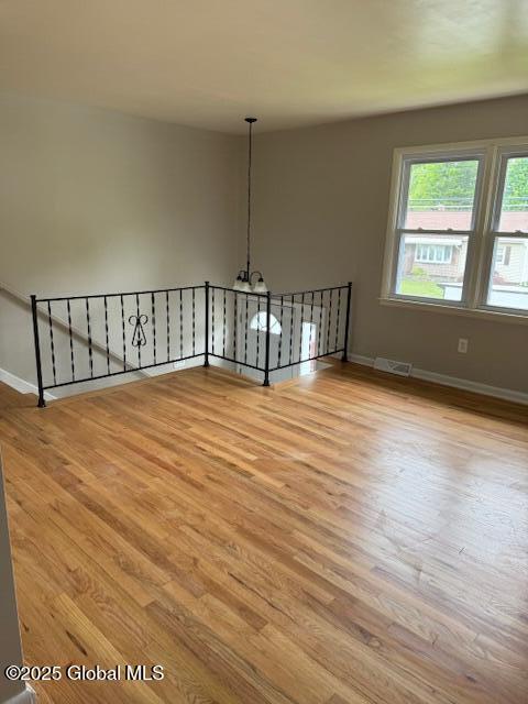 3 Loralee Dr, Colonie Village, NY 12205 - spare room with wood finished floors, baseboards, and a chandelier