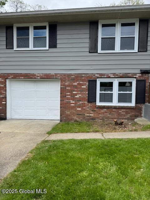 3 Loralee Dr, Colonie Village, NY 12205 - view of front facade featuring brick siding, an attached garage, concrete driveway, and a front lawn