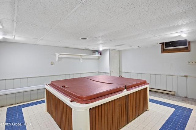 misc room featuring a baseboard radiator, a paneled ceiling, light tile patterned floors, a wainscoted wall, and pool table