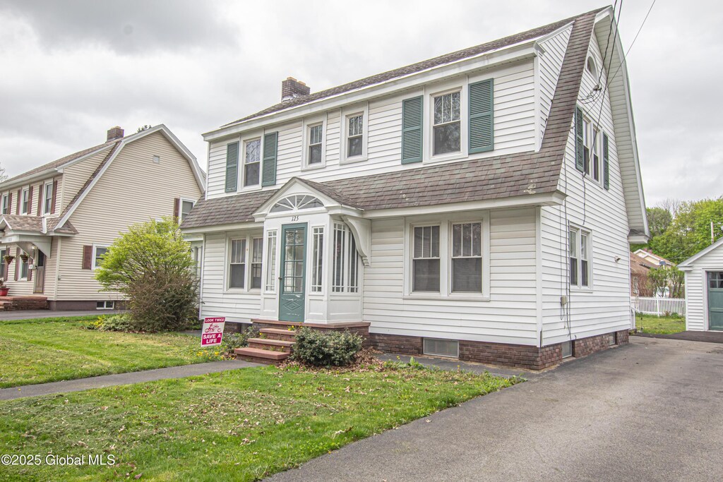125 5th Ave, Gloversville, NY 12078 - dutch colonial featuring a gambrel roof, a chimney, a front yard, and a shingled roof