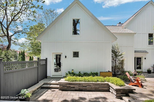 18 Granite St, Saratoga Springs, NY 12866 - rear view of property with board and batten siding, roof with shingles, and a patio area