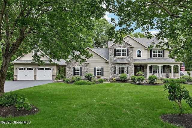 9 Meghan Ct, Wilton, NY 12866 - view of front of home with stone siding, a garage, covered porch, driveway, and a front yard
