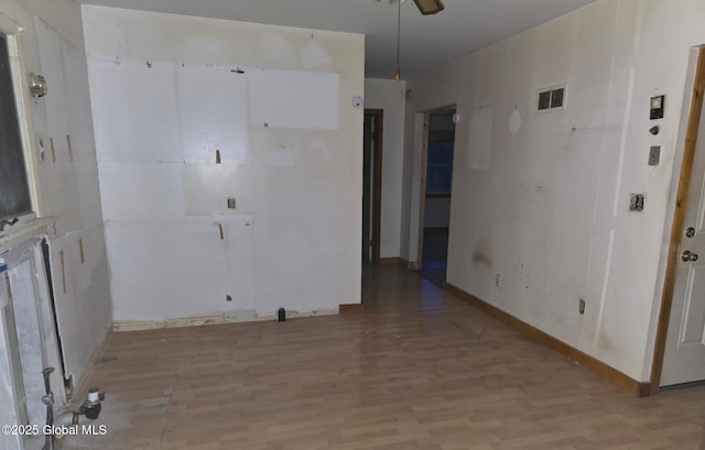 spare room with light wood finished floors, a ceiling fan, and baseboards