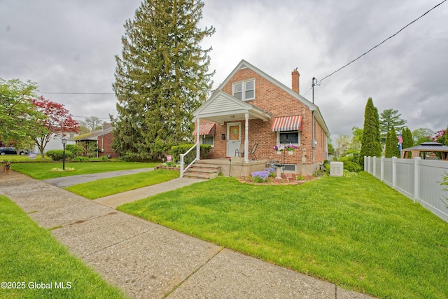 view of front of home featuring brick siding, a chimney, and a porch