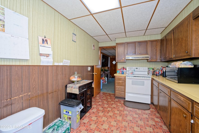 kitchen featuring white electric range, stainless steel microwave, under cabinet range hood, light countertops, and a drop ceiling