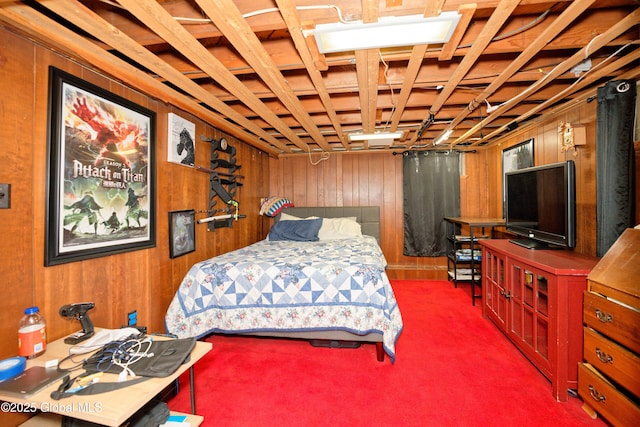 carpeted bedroom featuring wood walls