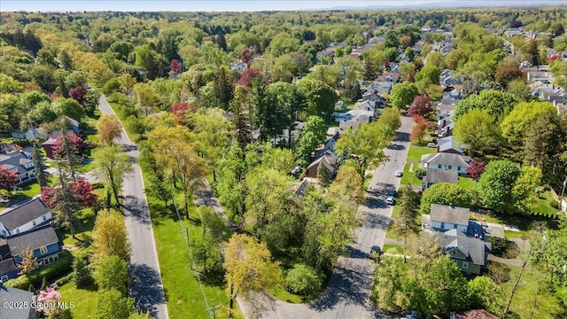 aerial overview of property's location featuring a forest and nearby suburban area
