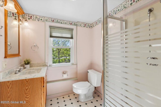 bathroom featuring a shower stall, toilet, vanity, and tile patterned floors