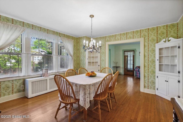 dining room with wallpapered walls, radiator heating unit, a chandelier, baseboards, and healthy amount of natural light
