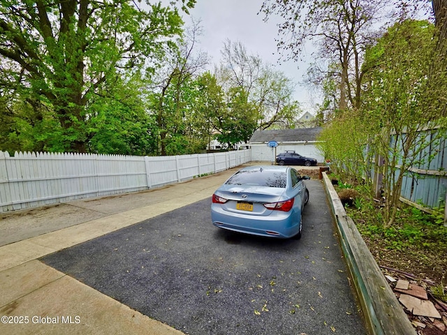 view of parking / parking lot featuring fence