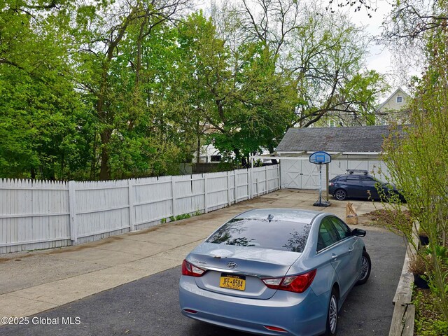 view of parking / parking lot featuring fence