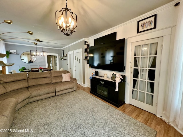 living room with a chandelier, crown molding, and wood finished floors