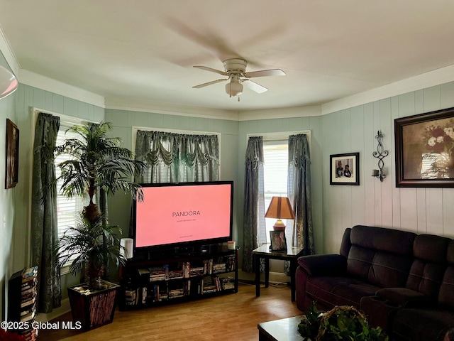 living room with ornamental molding, ceiling fan, and wood finished floors