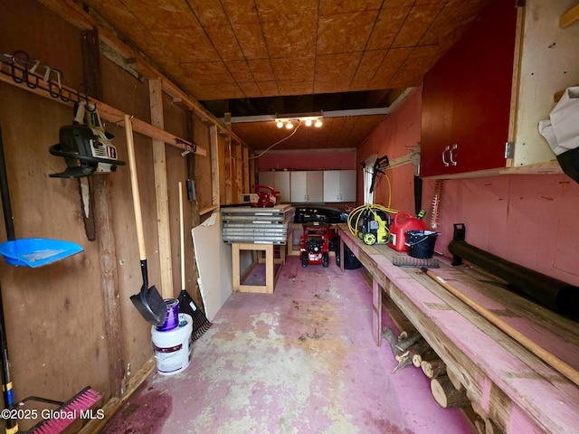 misc room with unfinished concrete flooring and a workshop area