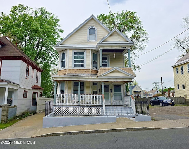 view of front of home with covered porch and fence