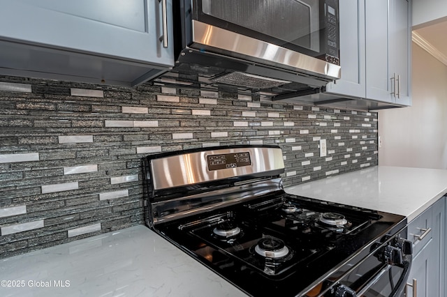 kitchen featuring range with gas cooktop, stainless steel microwave, backsplash, light countertops, and marble finish flooring