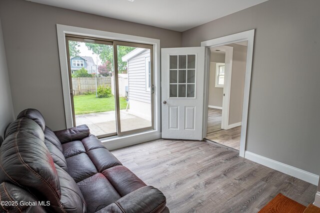 living area featuring light wood-style floors and baseboards