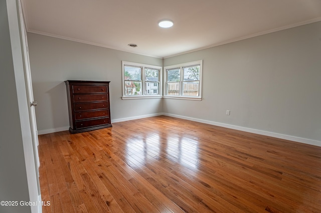 unfurnished bedroom featuring ornamental molding, light wood finished floors, and baseboards