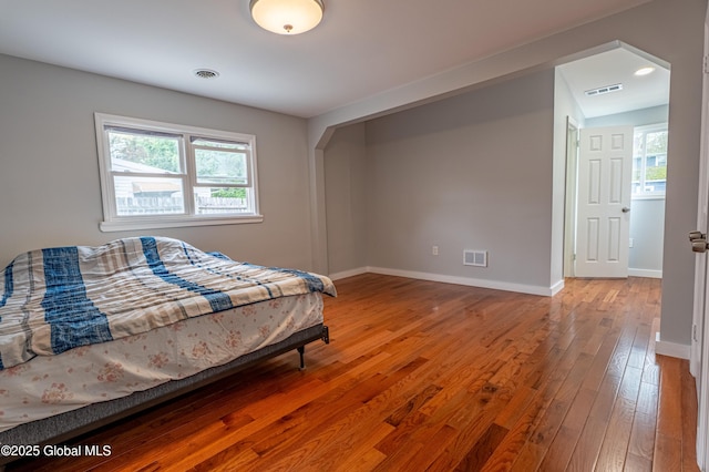 bedroom with hardwood / wood-style flooring and baseboards