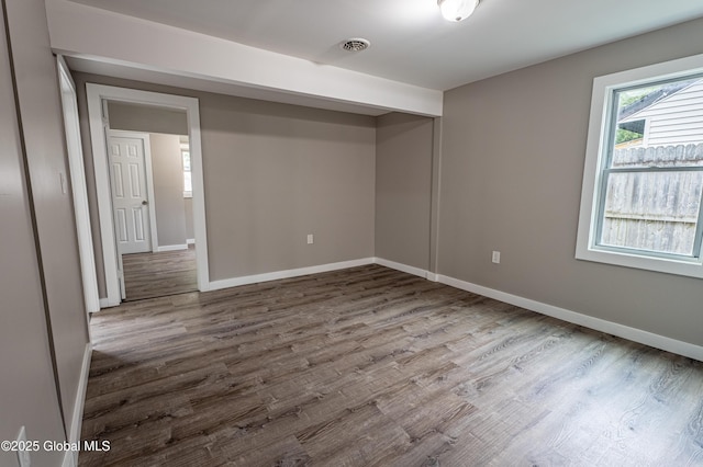 empty room featuring dark wood finished floors and baseboards