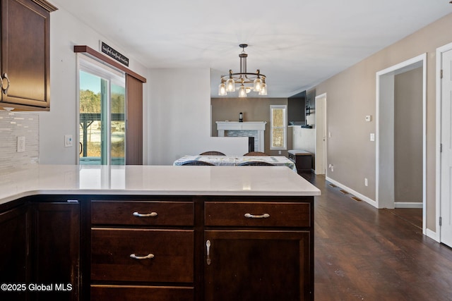 23 Line Dr, Brunswick, NY 12180 - kitchen featuring light countertops, dark brown cabinets, dark wood-style floors, baseboards, and a peninsula