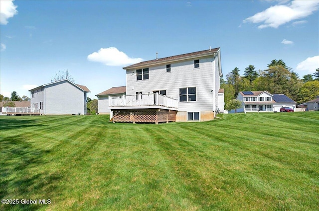 back of property with a yard and a wooden deck