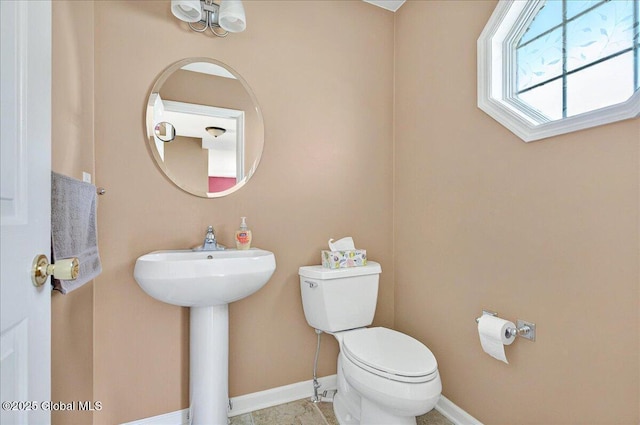 bathroom featuring toilet and baseboards