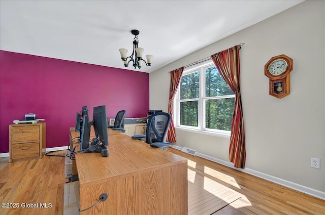 office space featuring wood finished floors, baseboards, and a chandelier