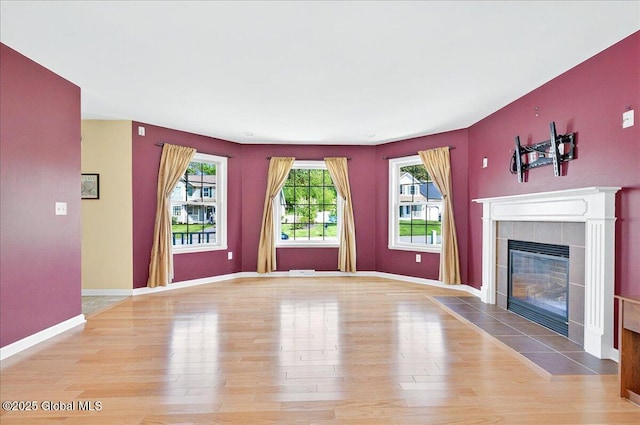 unfurnished living room featuring wood finished floors, a fireplace, and baseboards