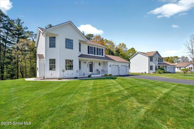 view of front facade with driveway, a porch, a garage, and a front lawn