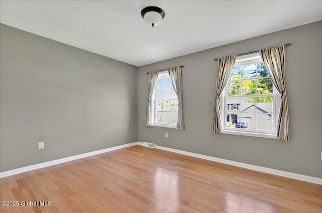 unfurnished room with light wood-style floors and baseboards