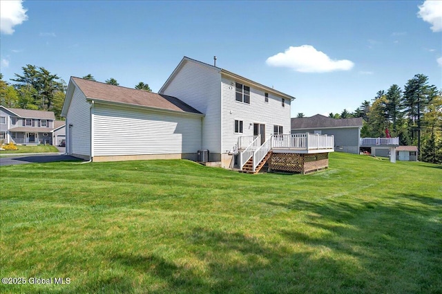 back of property with a deck and a lawn