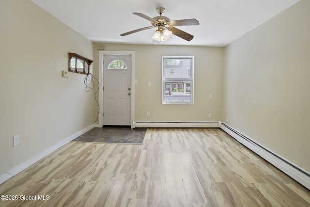 821 7th St, Rensselaer, NY 12144 - foyer entrance with baseboard heating, wood finished floors, ceiling fan, and baseboards