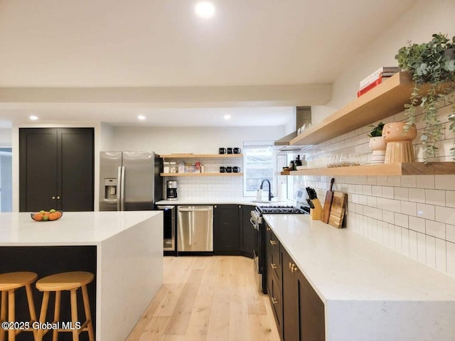 177 Glen Lake Rd, Queensbury, NY 12845 - kitchen with open shelves, appliances with stainless steel finishes, light wood-style floors, decorative backsplash, and light countertops