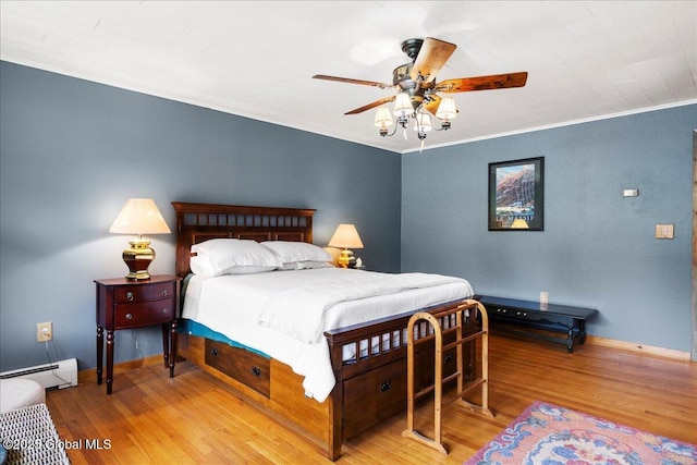 1 High Pines Ter Unit 1C, Chester, NY 12817 - bedroom with a baseboard radiator, wood finished floors, baseboards, ornamental molding, and a ceiling fan