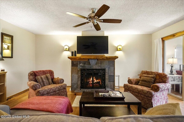 1 High Pines Ter Unit 1C, Chester, NY 12817 - living room featuring wood finished floors, a tile fireplace, a textured ceiling, a ceiling fan, and baseboards