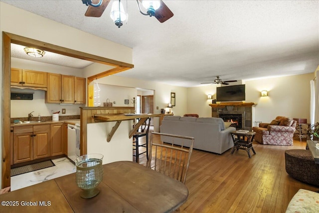 1 High Pines Ter Unit 1C, Chester, NY 12817 - dining space with ceiling fan, light wood-style flooring, a warm lit fireplace, and a textured ceiling