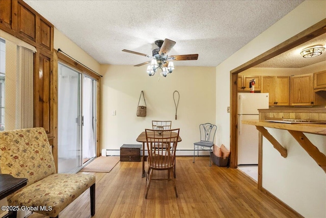 1 High Pines Ter Unit 1C, Chester, NY 12817 - dining space with a textured ceiling, light wood-type flooring, a ceiling fan, a baseboard heating unit, and baseboards