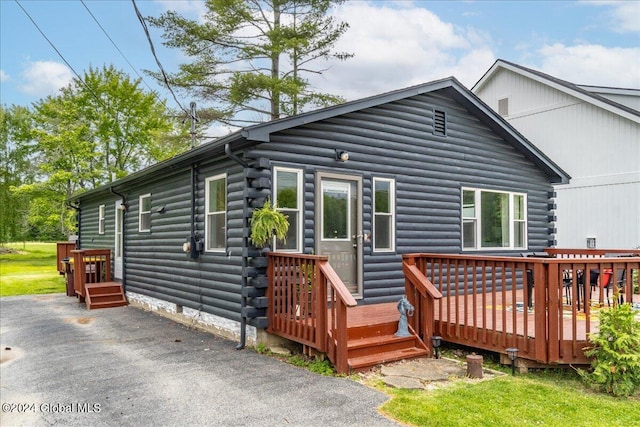 rear view of property featuring log exterior, a wooden deck, and crawl space