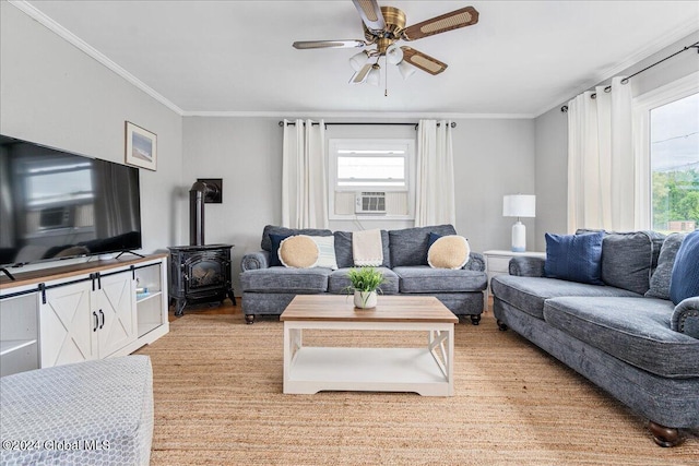 living room with crown molding, ceiling fan, and a wood stove