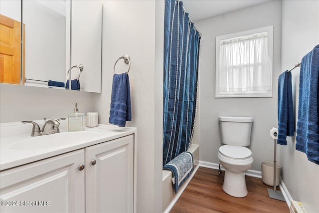 full bath featuring toilet, vanity, wood finished floors, baseboards, and shower / bath combination with curtain
