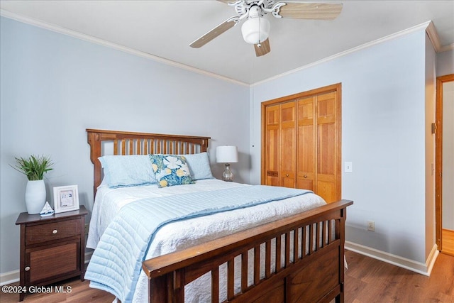 bedroom with crown molding, wood finished floors, baseboards, a closet, and ceiling fan