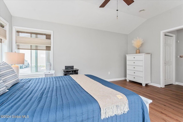 bedroom featuring wood finished floors, baseboards, lofted ceiling, and ceiling fan