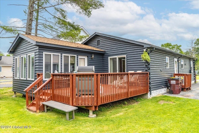 back of house featuring a lawn and a wooden deck
