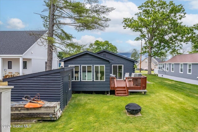 rear view of property featuring a lawn, faux log siding, and a wooden deck