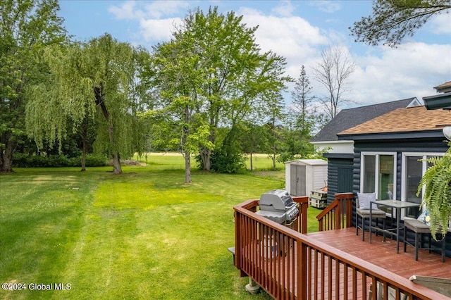 view of green lawn featuring a shed, a deck, and an outbuilding