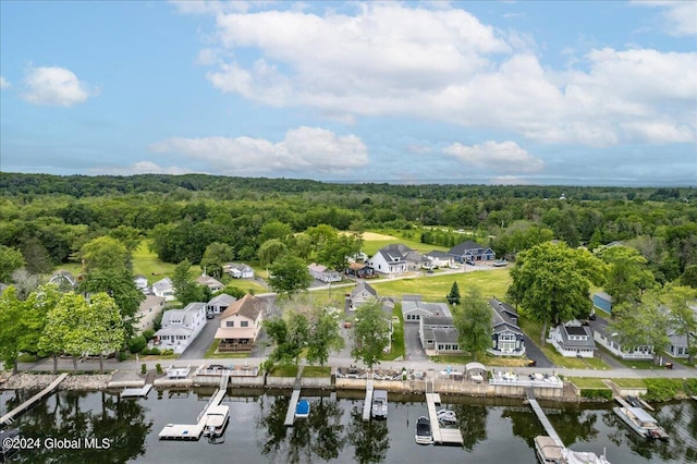 aerial overview of property's location featuring a forest, a nearby body of water, and nearby suburban area