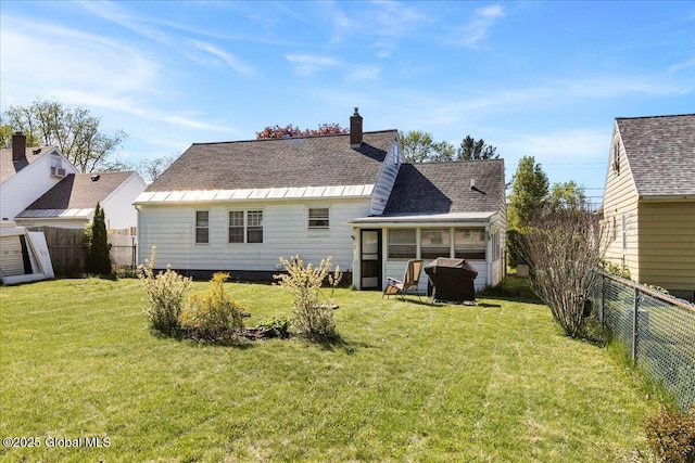 back of property with a sunroom, a chimney, and a shingled roof