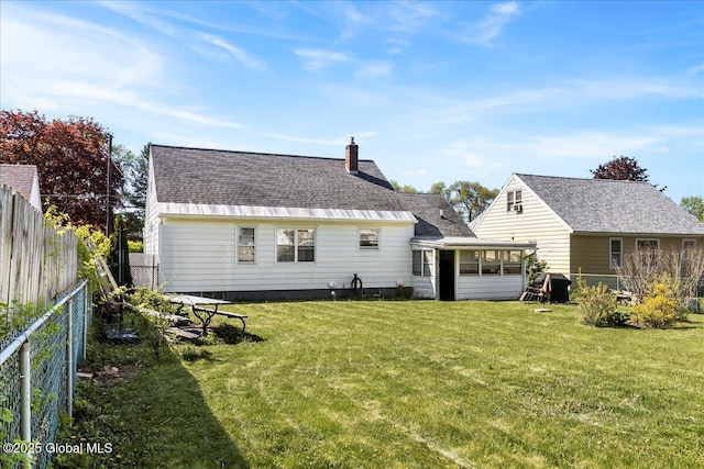 back of house with a chimney and a sunroom